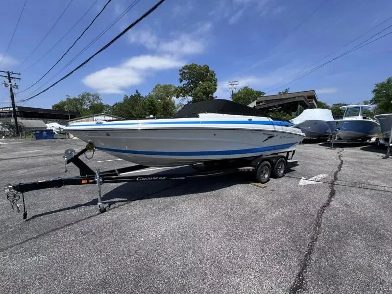 Slide: The Image of 2023 Crownline 240 SS boat on trailer in parking lot, clear sky background. - 3
