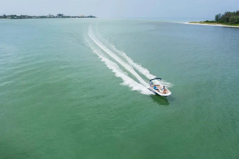 Slide: The Image of 2025 Hurricane SunDeck Sport 185 OB cruising on open water, leaving a wake trail. - 11