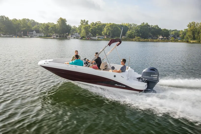 Slide: The Image of 2025 Hurricane SunDeck Sport 185 OB boat cruising on a serene lake. - 16