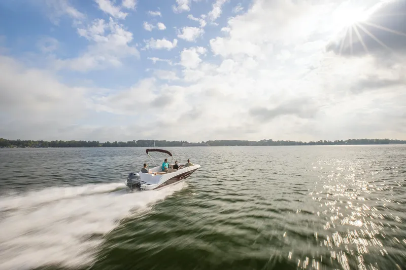 Slide: The Image of 2025 Hurricane SunDeck Sport 185 OB speeding on a sunny lake under a partly cloudy sky. - 19