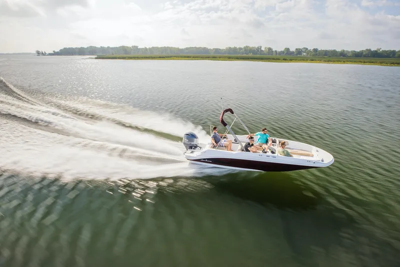 Slide: The Image of 2025 Hurricane SunDeck Sport 185 OB boat cruising on a serene lake. - 21