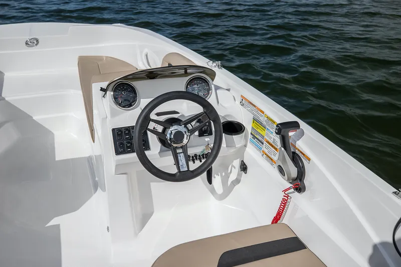 Slide: The Image of 2025 Hurricane SunDeck Sport 185 OB boat cockpit with steering wheel and controls on water. - 28