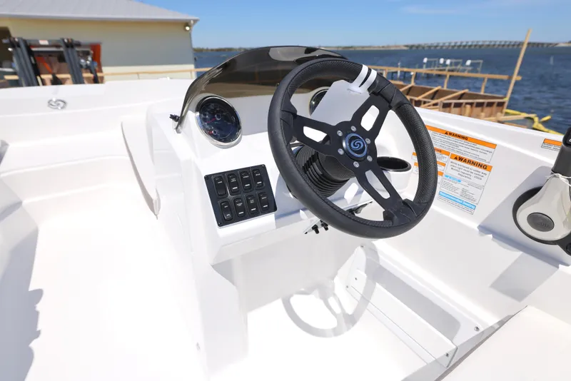 Slide: The Image of 2025 Hurricane SunDeck Sport 185 OB boat dashboard with steering wheel, controls, and waterfront view. - 8