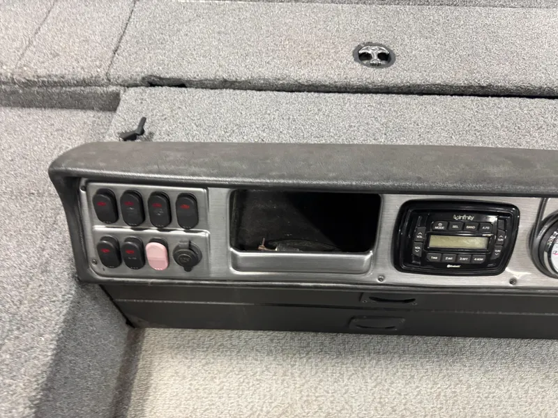 Slide: The Image of Control panel of a 2016 Lund 1875 Pro Guide boat with switches and a radio. - 10