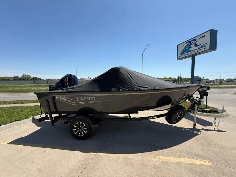 Slide: The Image of 2025 Lund 1650 Rebel XL Sport boat with cover on trailer, parked outdoors. - 4
