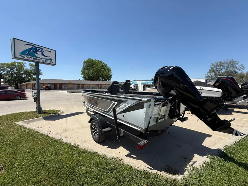 Slide: The Image of 2025 Lund 1875 Pro Guide boat on trailer at ABC dealership, sunny day. - 3