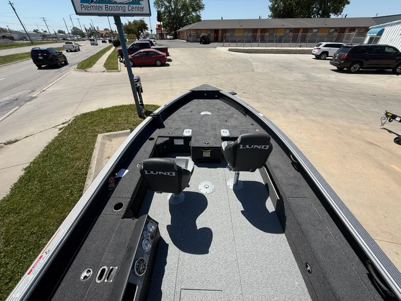 Slide: The Image of 2025 Lund 1875 Pro Guide boat parked near a road with visible traffic. - 6