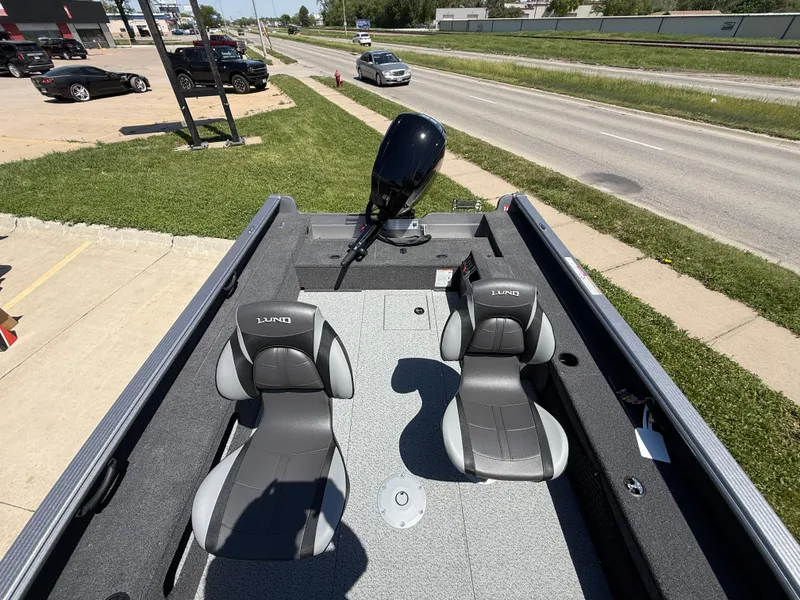 Slide: The Image of 2025 Lund 1875 Pro Guide boat with dual seats, parked near a road. - 7