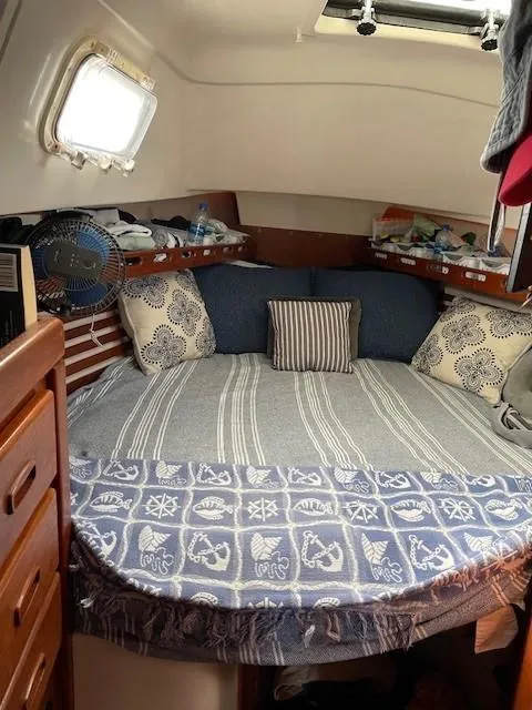 Slide: The Image of Cozy cabin interior of a 1980 Hunter 36 sailboat with nautical-themed bedding. - 10