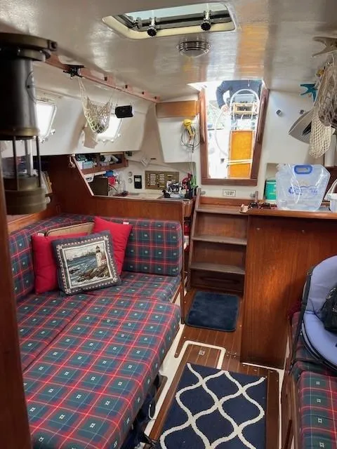 Slide: The Image of Cozy interior of a 1980 Hunter 36 sailboat with plaid seating and nautical decor. - 11