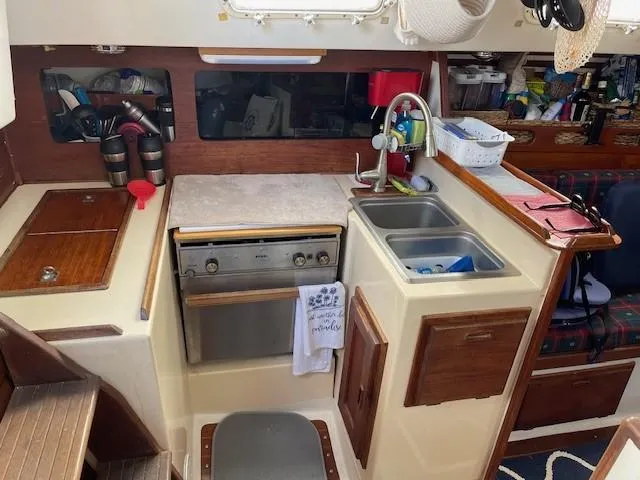 Slide: The Image of Compact kitchen in a 1980 Hunter 36 sailboat with stove, sink, and storage. - 14