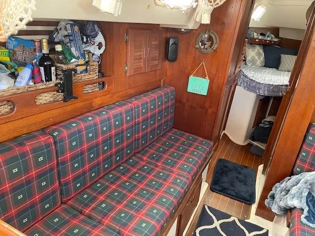 Slide: The Image of Cozy interior of 1980 Hunter 36 sailboat with plaid seating and wooden accents. - 15