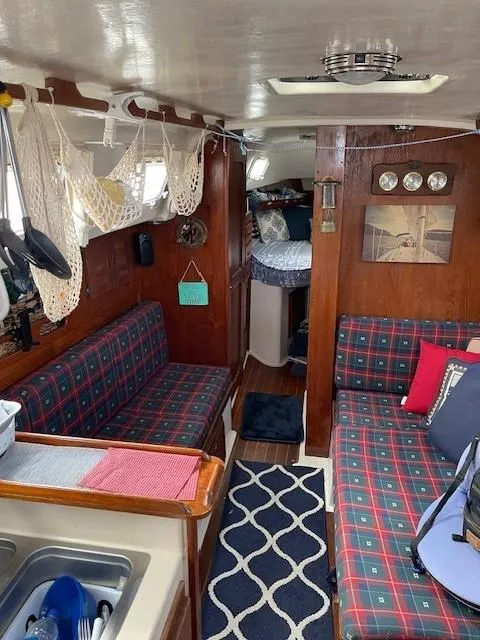 Slide: The Image of Interior of a 1980 Hunter 36 sailboat with cozy seating and nautical decor. - 16