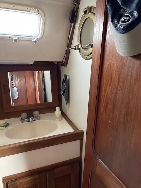 Slide: The Image of 1980 Hunter 36 yacht bathroom with sink, mirror, and porthole window. - 19