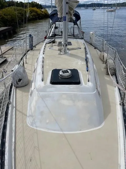 Slide: The Image of 1980 Hunter 36 sailboat docked, featuring a clean deck and visible hatch. - 21