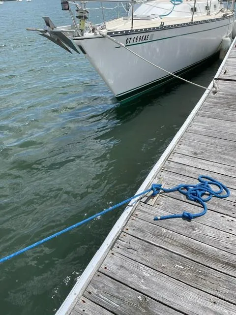 Slide: The Image of 1980 Hunter 36 sailboat docked with blue mooring line on wooden pier. - 22