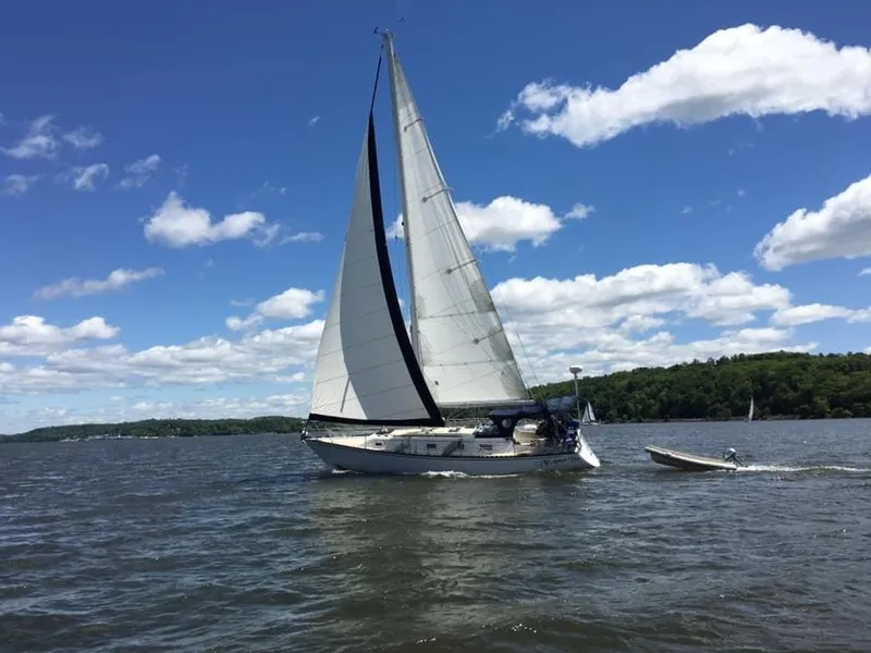 Slide: The Image of 1980 Hunter 36 sailboat cruising on a sunny day with blue skies and scattered clouds. - 3