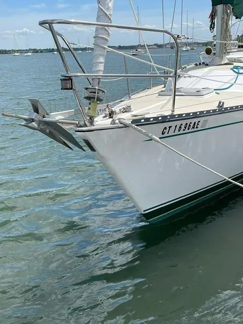 Slide: The Image of 1980 Hunter 36 sailboat anchored in calm waters, featuring a visible anchor and registration number. - 5