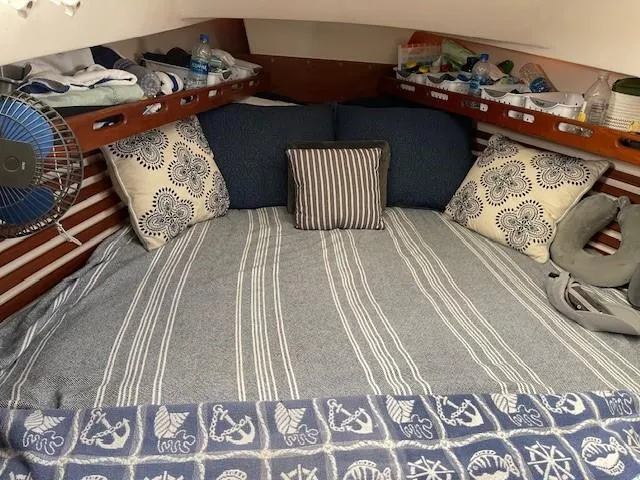 Slide: The Image of Cozy cabin interior of 1980 Hunter 36 sailboat with striped bedding and decorative pillows. - 8