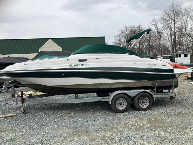 The Image of 2002 Four Winns 214 Funship boat on trailer, green and white, parked outdoors. - 0