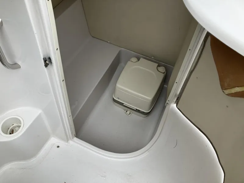 Slide: The Image of 2002 Four Winns 214 Funship boat interior with portable toilet in compact bathroom space. - 10