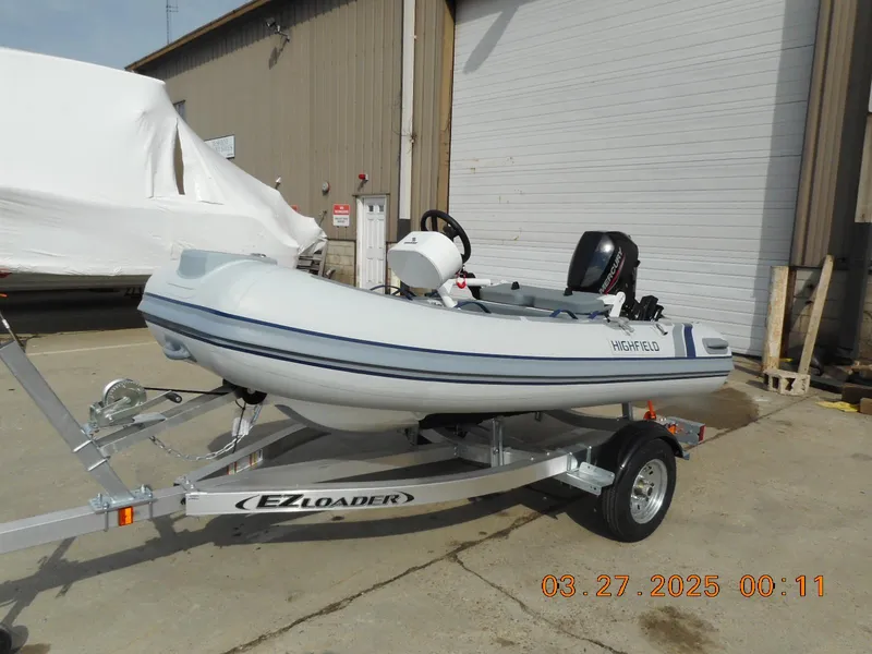 Slide: The Image of 2025 Highfield Classic 310 boat on EZ Loader trailer, parked outdoors. - 0
