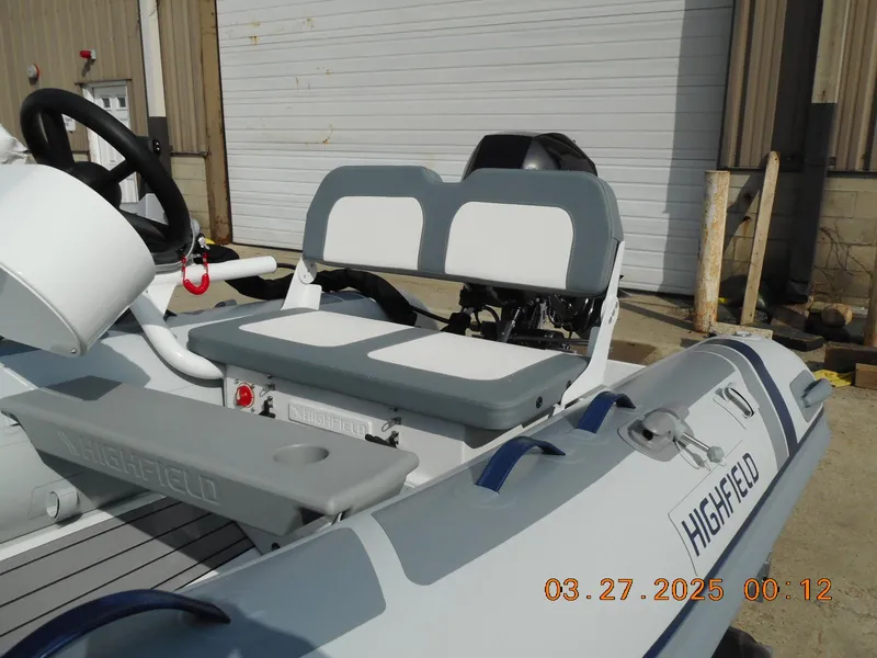 Slide: The Image of 2025 Highfield Classic 310 boat with dual seats and steering wheel, docked outdoors. - 4