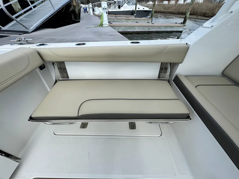 Slide: The Image of 2019 Pursuit DC 325 Dual Console boat with beige seating at the dock. - 11
