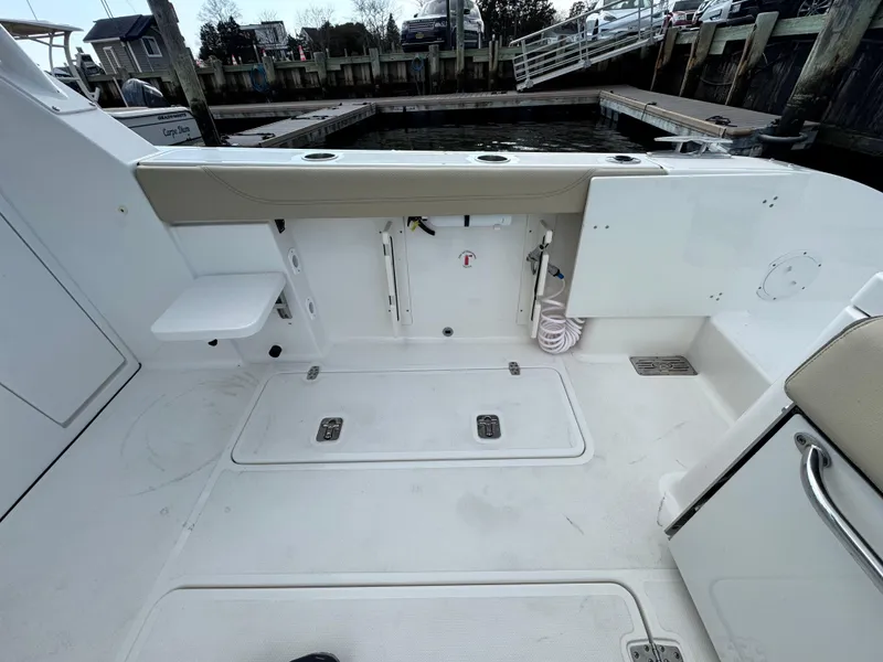 Slide: The Image of 2019 Pursuit DC 325 Dual Console boat deck with storage compartments and seating. - 12