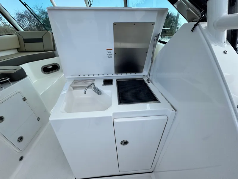 Slide: The Image of 2019 Pursuit DC 325 Dual Console boat interior with sink and grill station. - 14