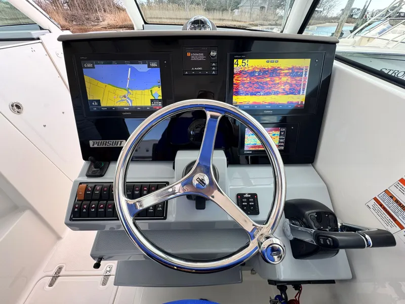 Slide: The Image of 2019 Pursuit DC 325 Dual Console helm with navigation screens and steering wheel. - 23