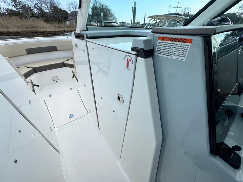 Slide: The Image of 2019 Pursuit DC 325 Dual Console boat interior, featuring seating and storage compartments. - 24