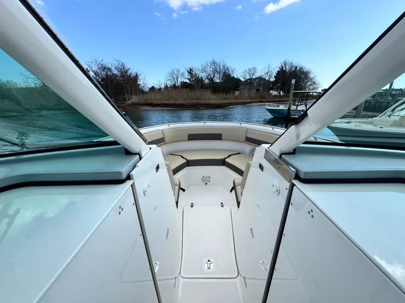 Slide: The Image of 2019 Pursuit DC 325 Dual Console boat, open deck view, docked by calm waters. - 28