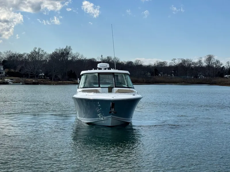 Slide: The Image of 2019 Pursuit DC 325 Dual Console boat on calm water, front view. - 3