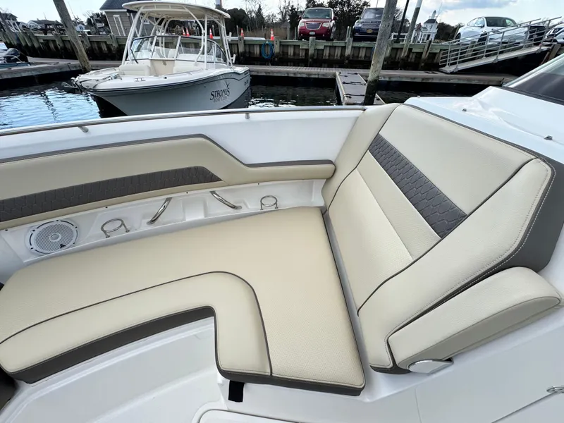 Slide: The Image of 2019 Pursuit DC 325 Dual Console boat with beige seating at a marina. - 30