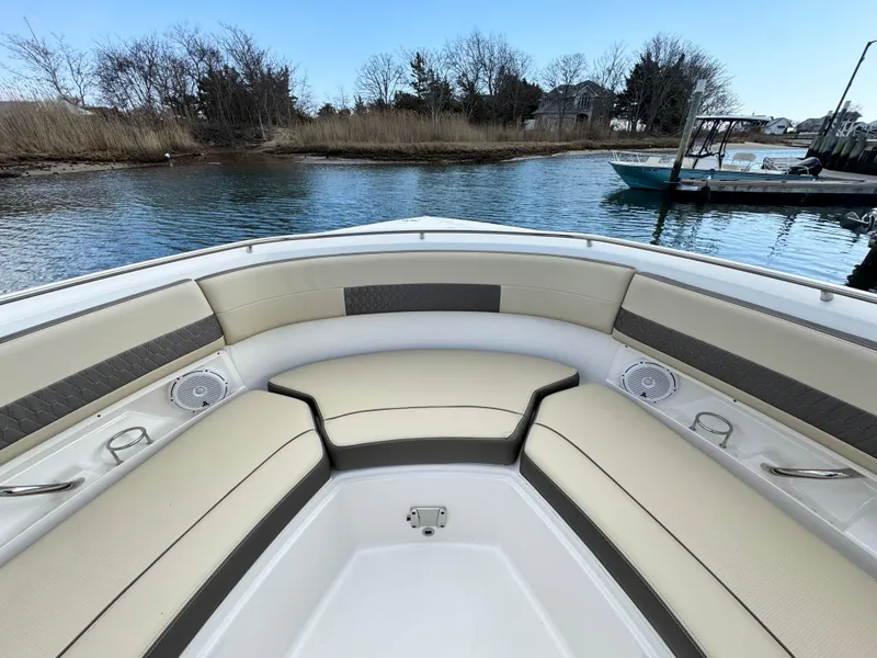 Slide: The Image of 2019 Pursuit DC 325 Dual Console boat with spacious seating, docked by a serene waterway. - 31