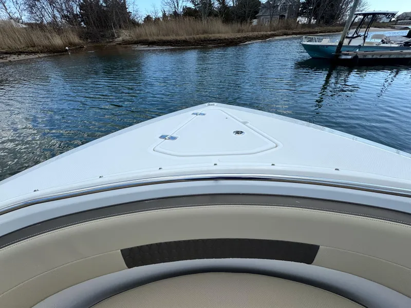 Slide: The Image of 2019 Pursuit DC 325 Dual Console boat on calm water near shoreline. - 32