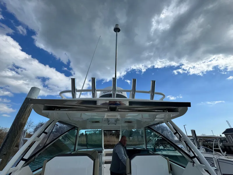 Slide: The Image of 2019 Pursuit DC 325 Dual Console boat under cloudy sky, docked with person onboard. - 36