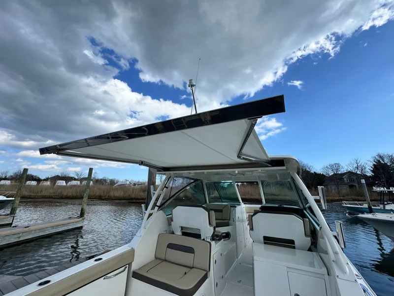 Slide: The Image of 2019 Pursuit DC 325 Dual Console boat with canopy, docked under cloudy sky. - 37