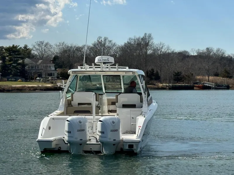 Slide: The Image of 2019 Pursuit DC 325 Dual Console boat with twin engines on a calm waterway. - 6