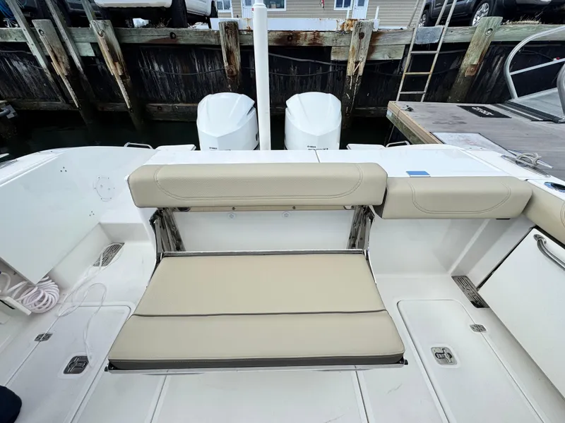 Slide: The Image of 2019 Pursuit DC 325 Dual Console boat with beige seating and twin engines at dock. - 9