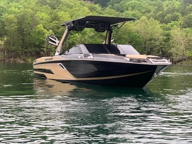 Slide: The Image of 2021 Centurion Ri265 boat on a serene lake with lush green trees. - 13