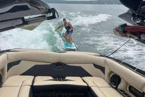 Slide: The Image of Person wakesurfing behind 2021 Centurion Ri265 boat on a lake. - 4