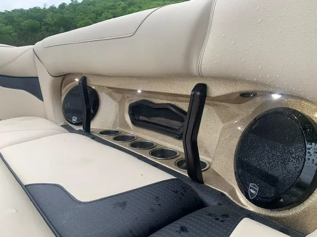 Slide: The Image of 2021 Centurion Ri265 boat interior with beige and black seating, cup holders, and speakers. - 6