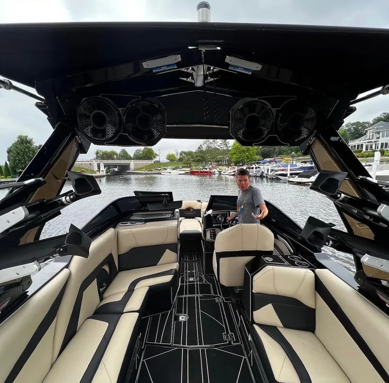 Slide: The Image of 2021 Centurion Ri265 boat interior with luxury seating and a person at the helm. - 9