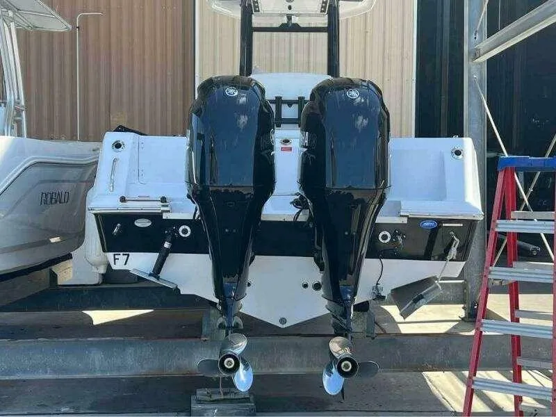 Slide: The Image of 2023 Tidewater 256 CC Adventure boat with dual outboard engines in a marina setting. - 3