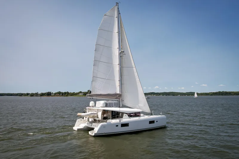 Slide: The Image of 2017 Lagoon 42 catamaran sailing on a calm lake under clear blue skies. - 8