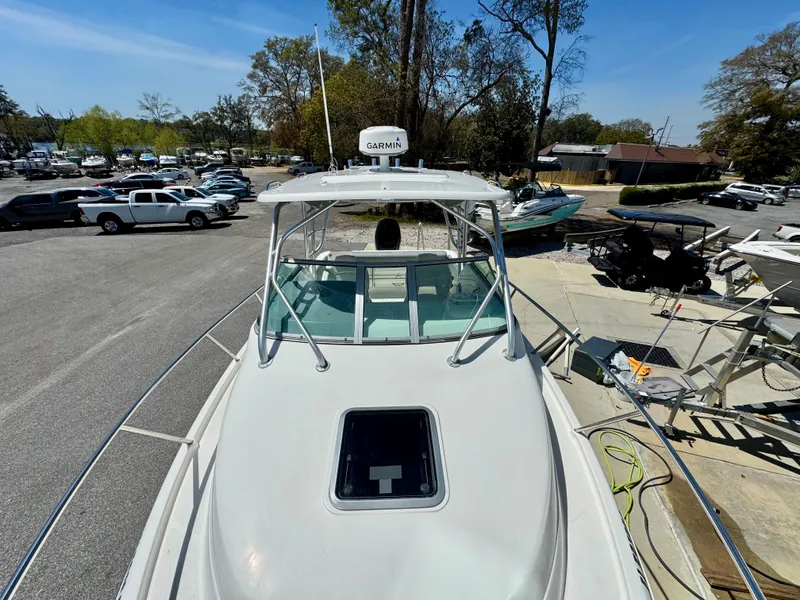 Slide: The Image of 2015 Robalo R245 Walkaround boat docked, featuring a Garmin radar and spacious deck. - 6