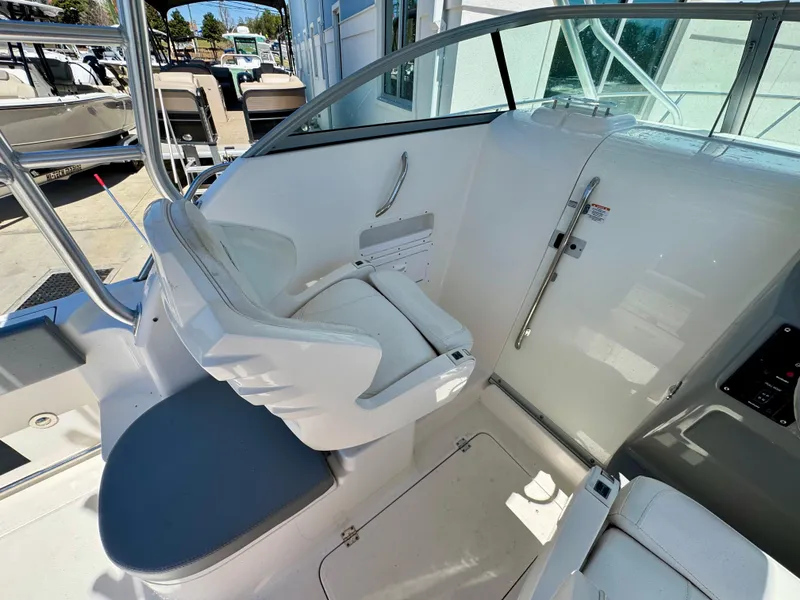 Slide: The Image of 2015 Robalo R245 Walkaround boat interior with white seating and helm area. - 9