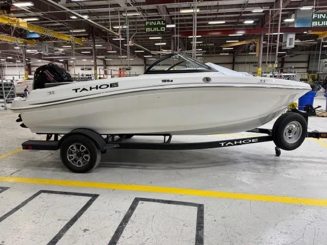 Slide: The Image of 2024 Tahoe 185 S boat on trailer in a factory setting. - 0